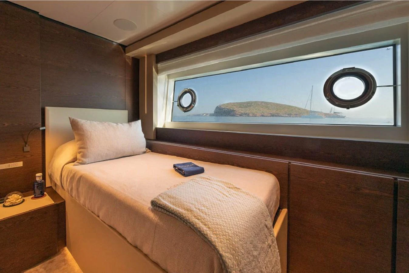 The guest stateroom offers a cozy and inviting space with a large window providing a scenic view. aboard ON Yacht for Sale