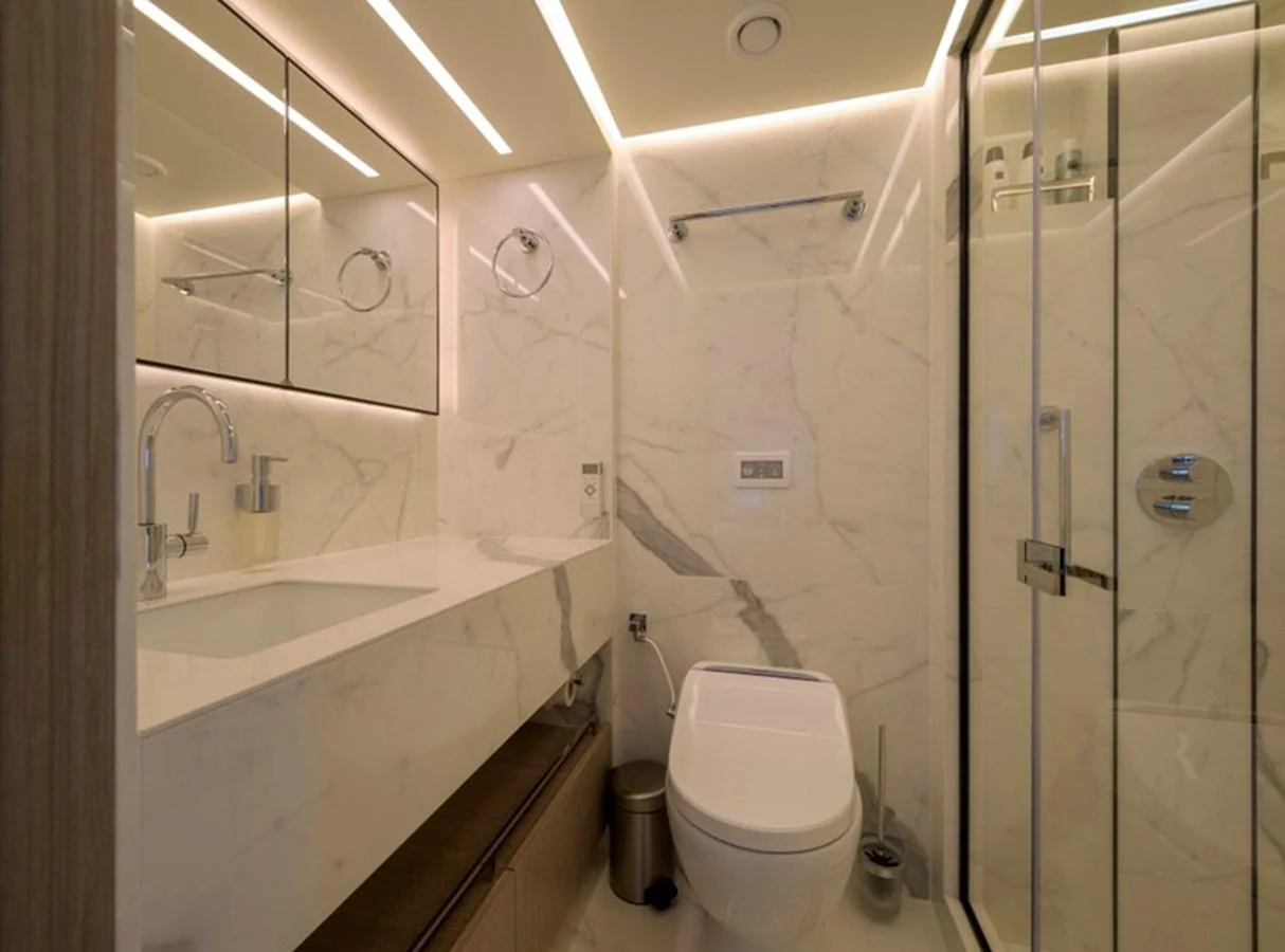 A luxurious bathroom with marble walls and modern fixtures. aboard BIG M Yacht for Sale