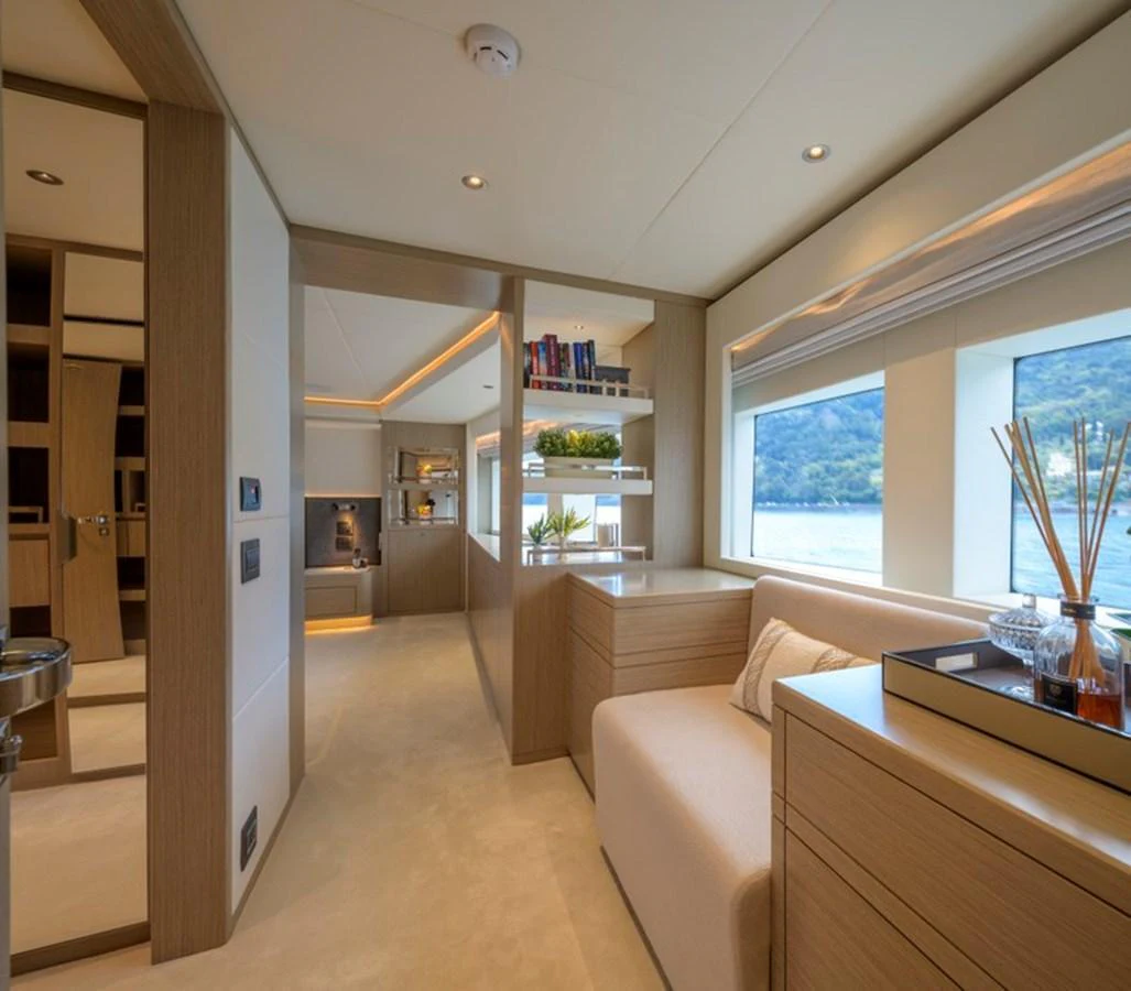 The yacht's interior features a cozy seating area with large windows offering scenic views. aboard BIG M Yacht for Sale