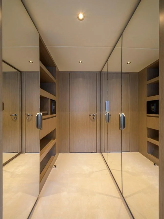 A sleek and modern interior hallway with mirrored walls and wooden accents. aboard BIG M Yacht for Sale