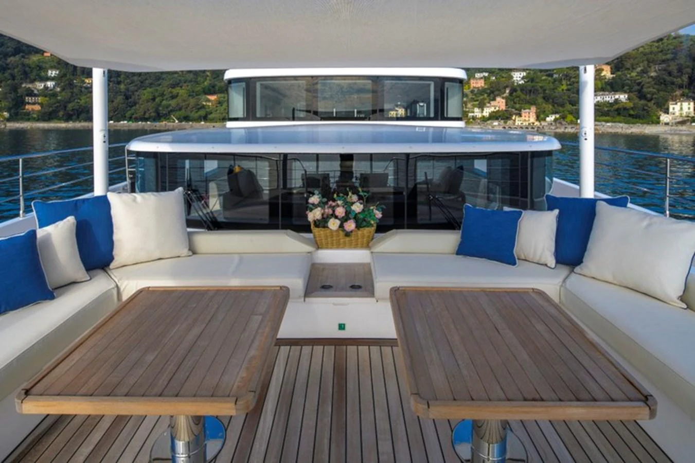 The aft deck features comfortable seating with wooden tables, perfect for outdoor relaxation and dining. aboard BIG M Yacht for Sale