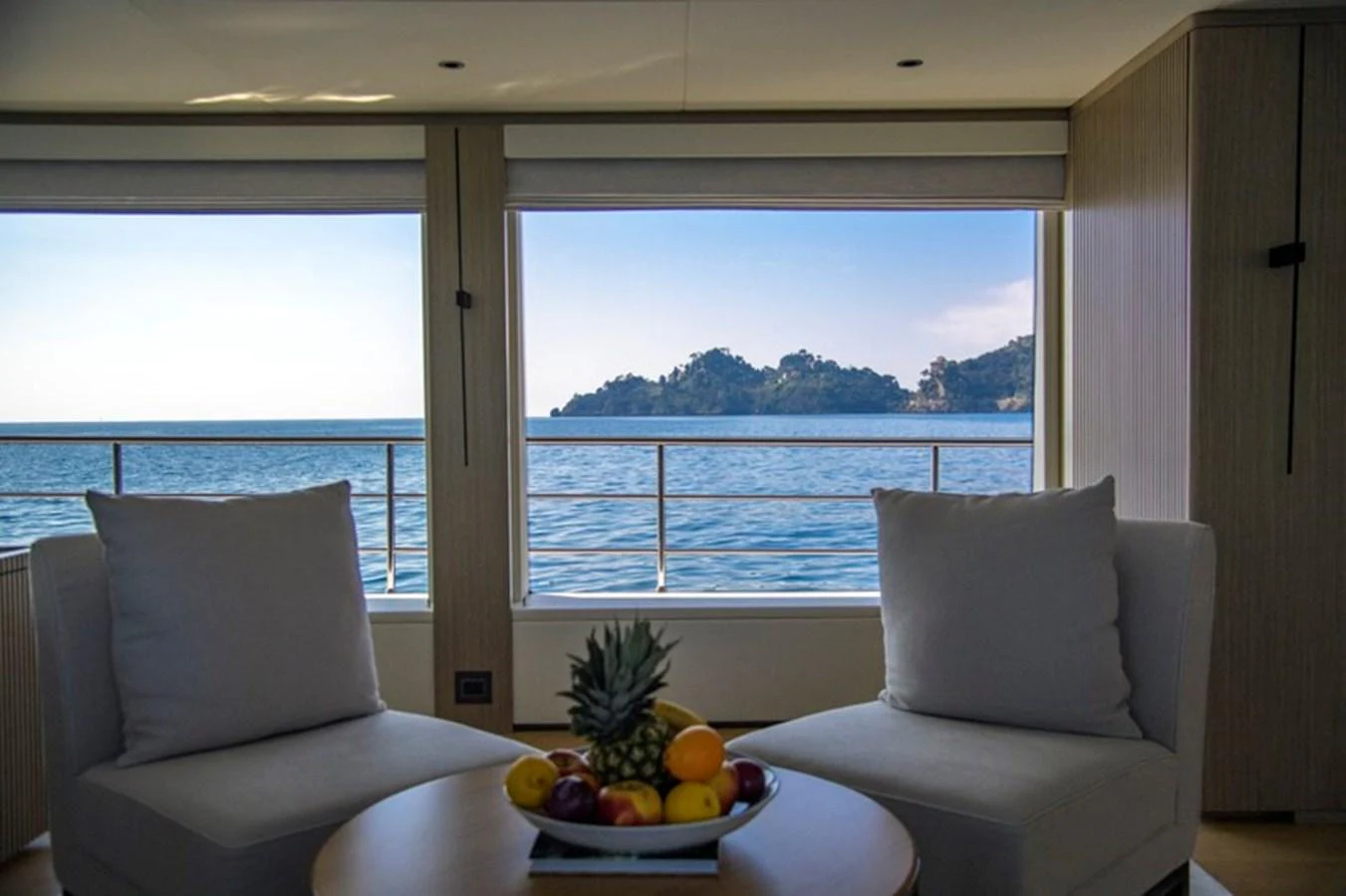 A serene interior seating area with large windows offering a stunning ocean view. aboard BIG M Yacht for Sale