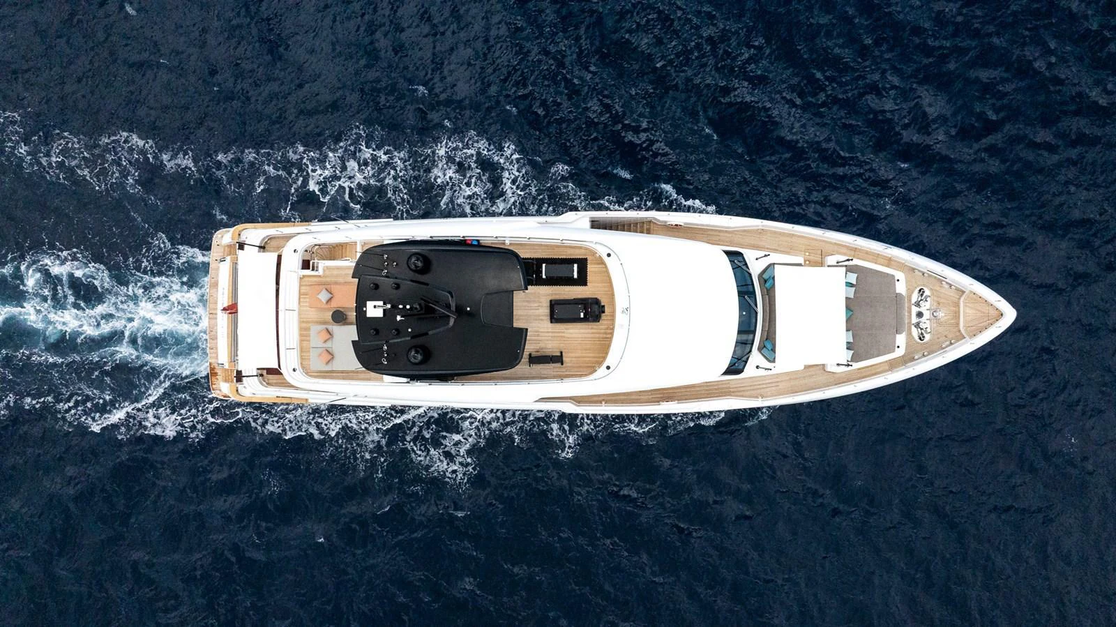 An aerial view of a luxurious yacht cruising through deep blue waters. aboard QUEEN J III Yacht for Sale
