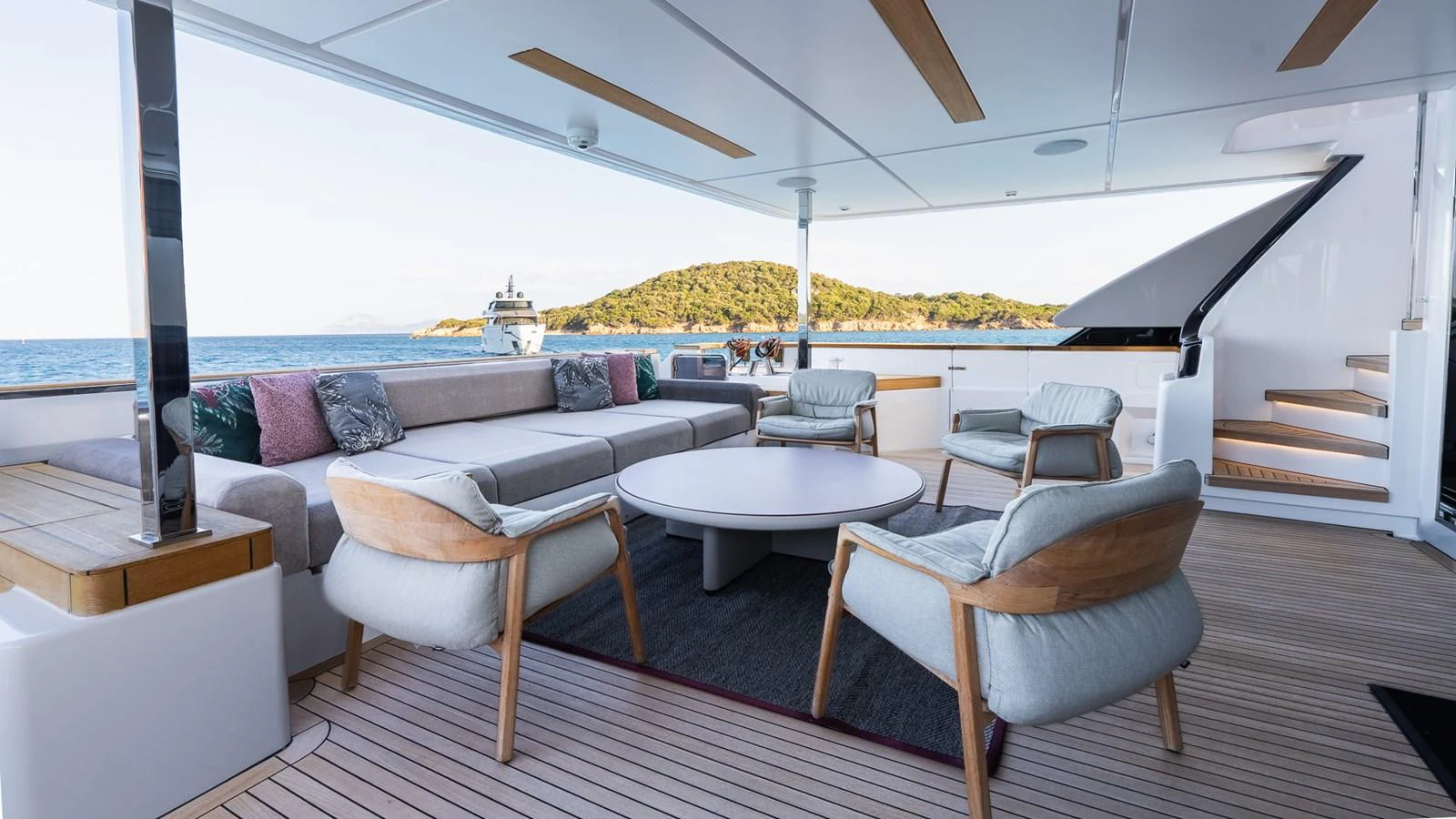 The aft deck features a stylish and comfortable seating area with a scenic ocean view. aboard QUEEN J III Yacht for Sale
