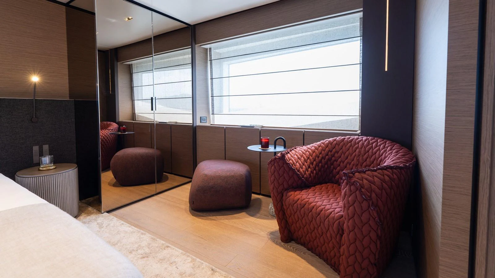 A cozy and stylish seating area inside the yacht, featuring a plush armchair and ottoman by a large window. aboard QUEEN J III Yacht for Sale