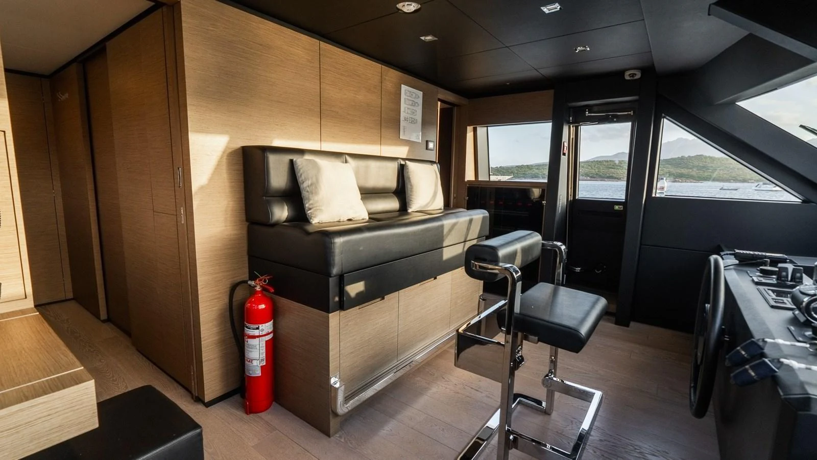 The helm area features modern seating and a sleek design with expansive windows offering a view of the water. aboard QUEEN J III Yacht for Sale