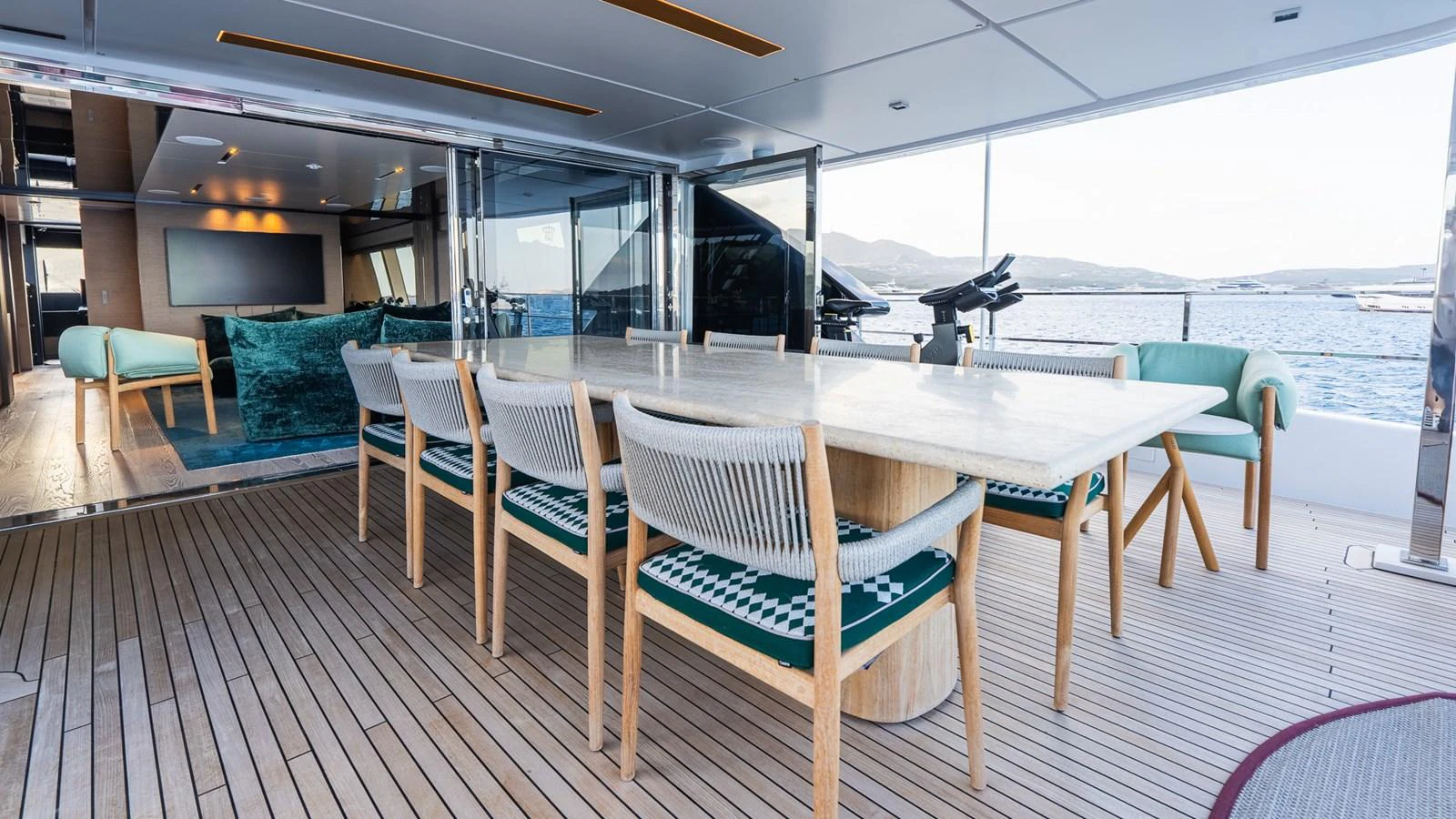 The aft deck features a spacious dining area with a large table and comfortable seating, perfect for alfresco meals with a view. aboard QUEEN J III Yacht for Sale
