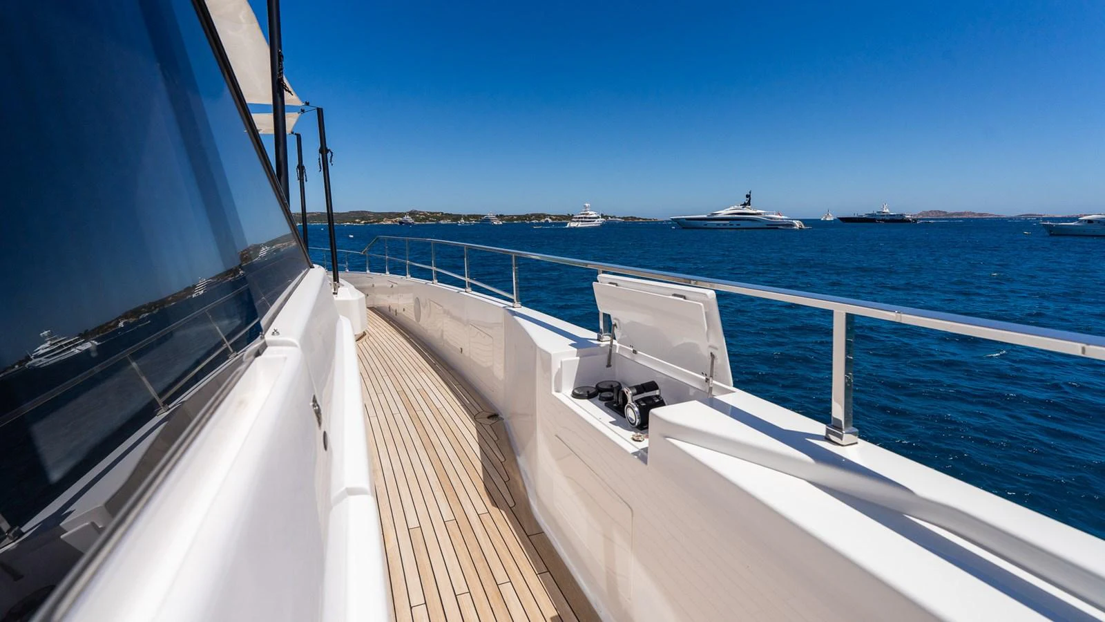 The yacht's side deck offers a sleek walkway with stunning ocean views. aboard QUEEN J III Yacht for Sale