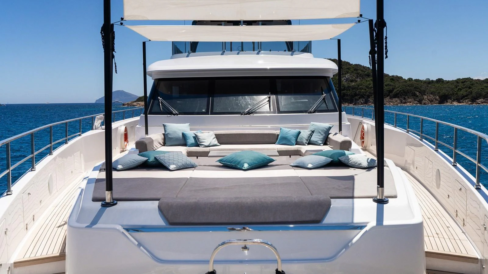 The yacht's foredeck features a luxurious sunbathing area with plush cushions and a retractable sunshade. aboard QUEEN J III Yacht for Sale