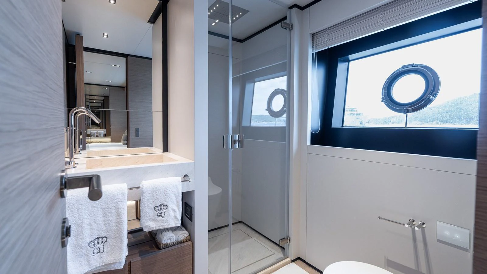 The yacht's bathroom features a modern design with a glass-enclosed shower and elegant fixtures. aboard QUEEN J III Yacht for Sale