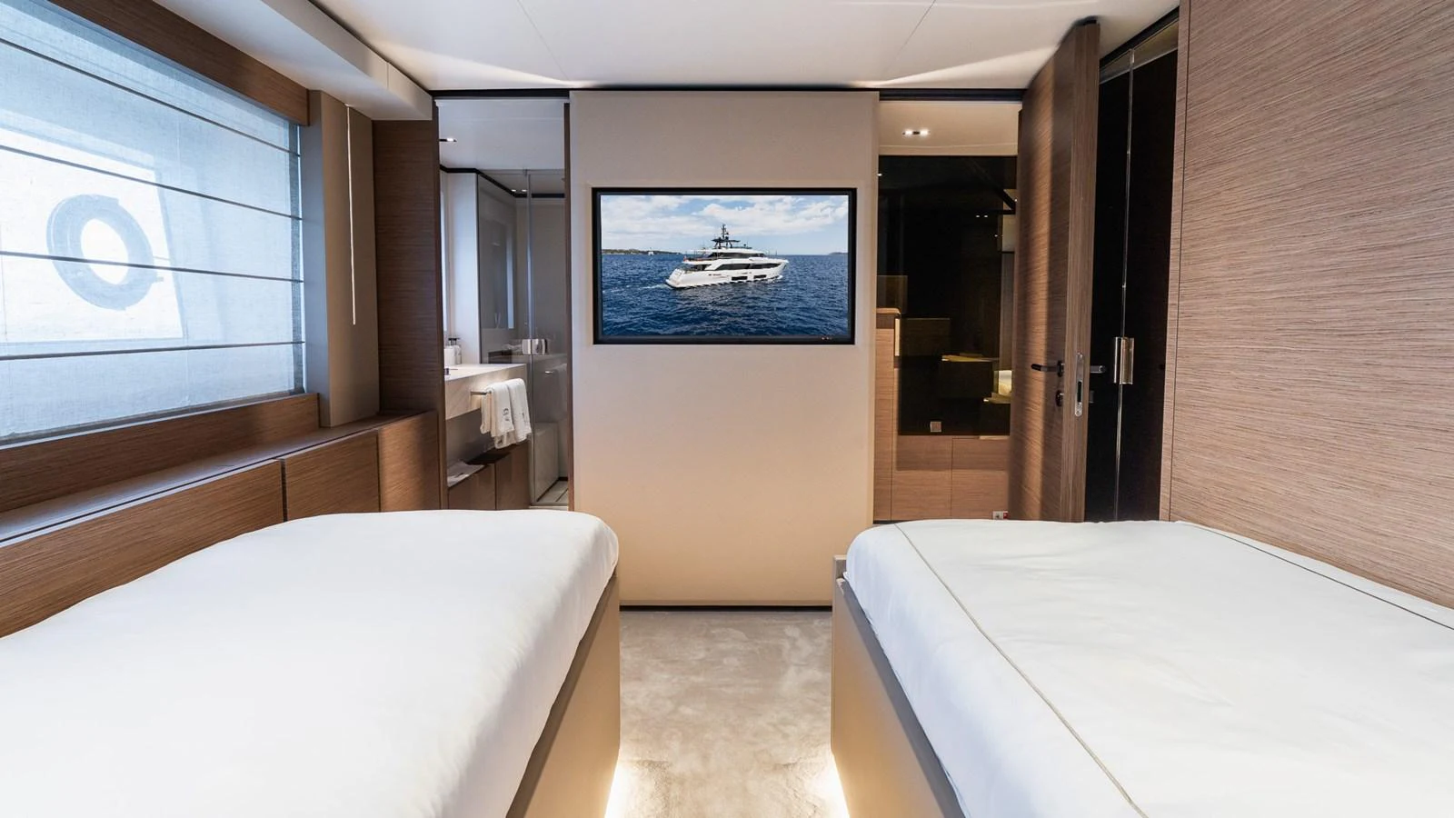 The stateroom features twin beds and a large flat-screen TV, creating a cozy and modern retreat. aboard QUEEN J III Yacht for Sale