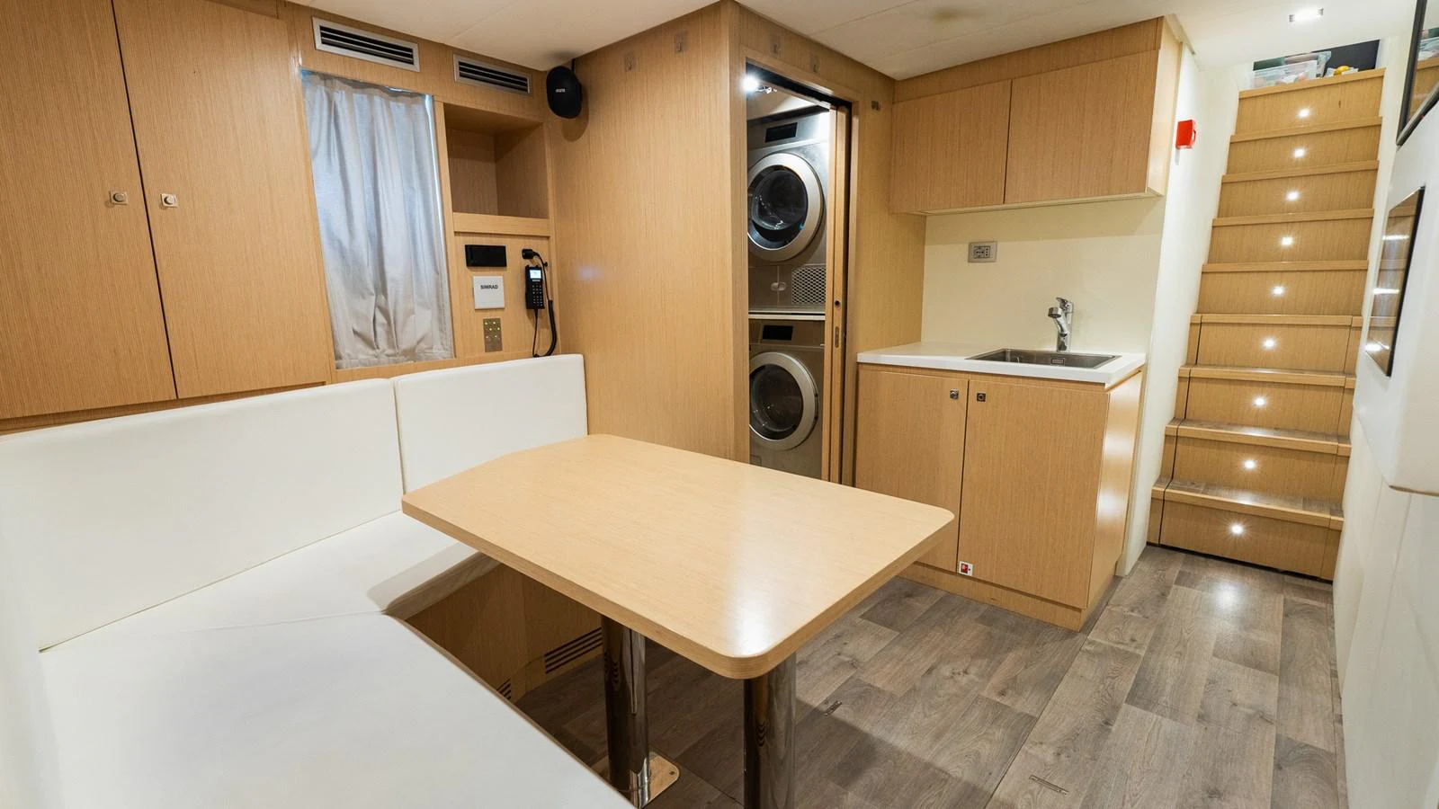 This cozy galley features a dining area, laundry facilities, and a staircase leading to the upper deck. aboard QUEEN J III Yacht for Sale