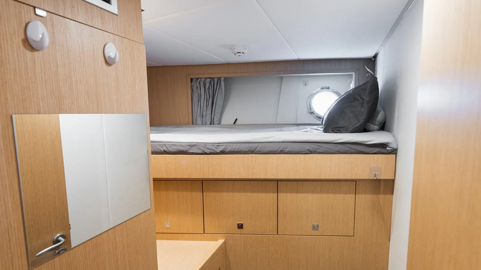 A cozy cabin with a single bed and natural wood finishes. aboard QUEEN J III Yacht for Sale