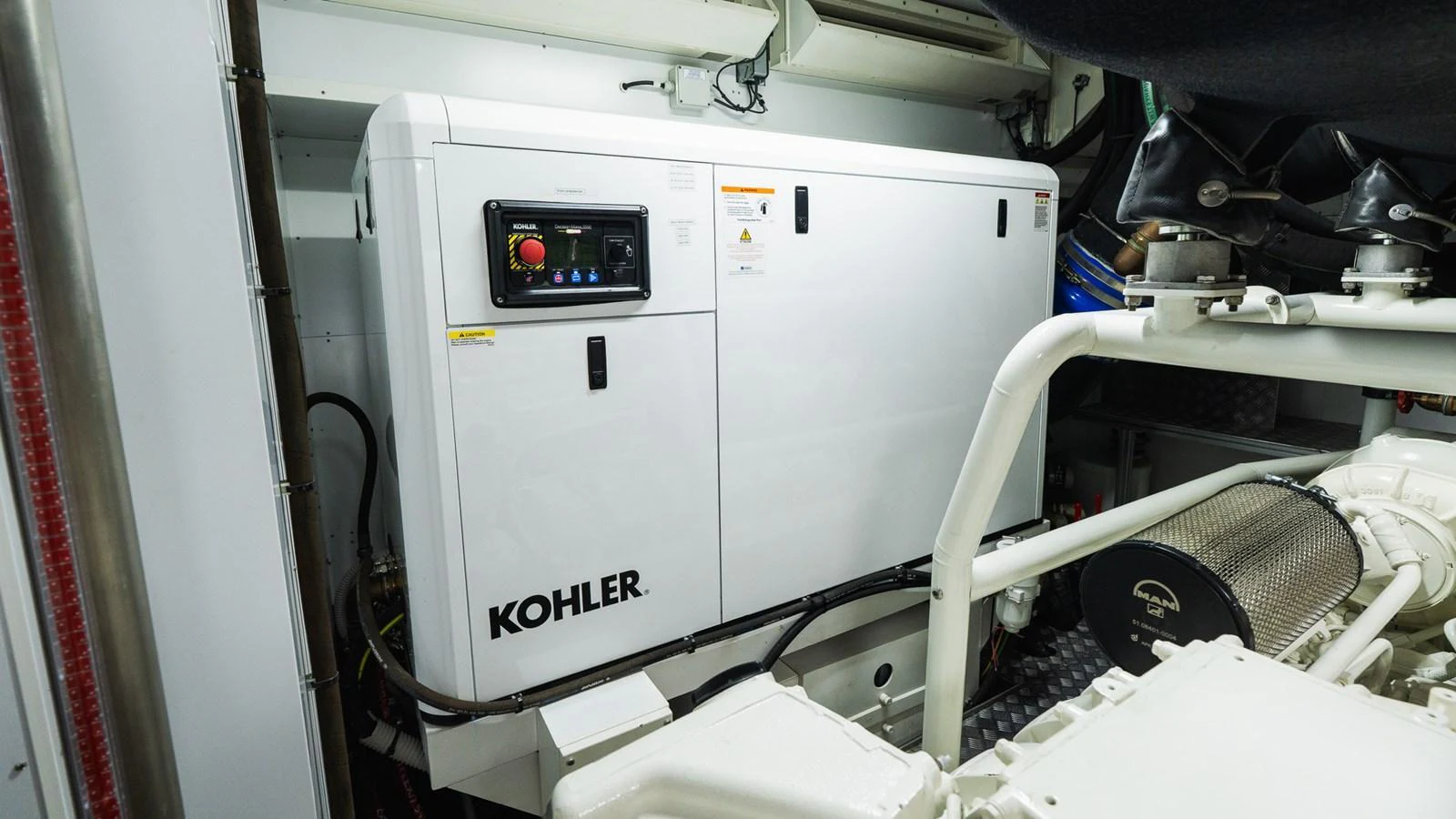 The image showcases the yacht's well-maintained engine room featuring a Kohler generator. aboard QUEEN J III Yacht for Sale