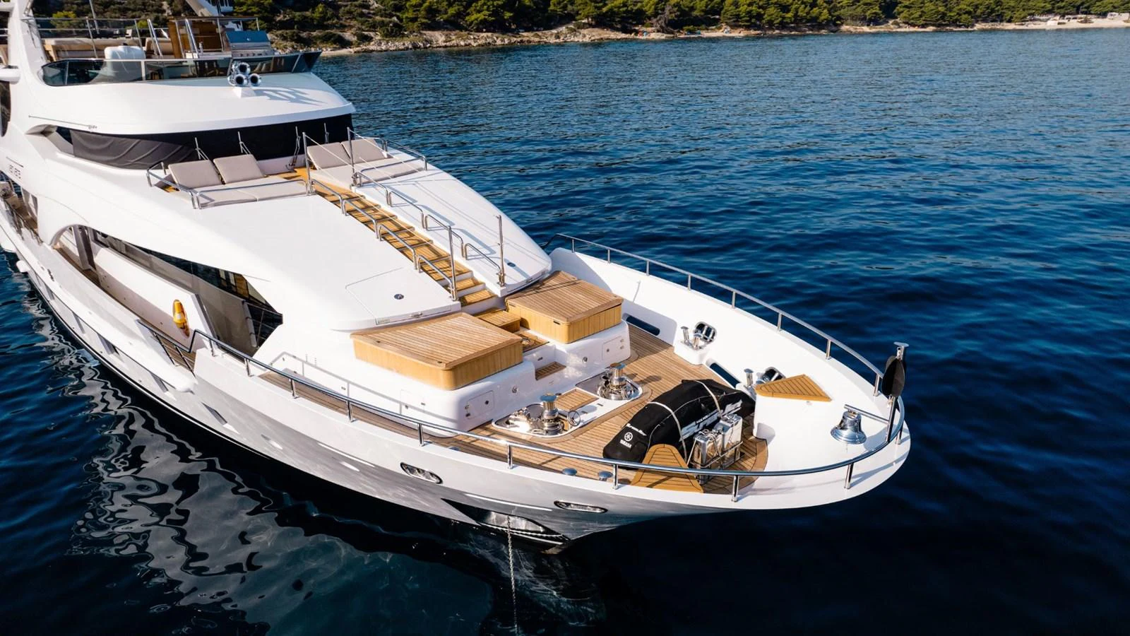 A luxurious yacht is anchored in calm waters, showcasing its sleek design and spacious deck areas. aboard AFINA Yacht for Sale