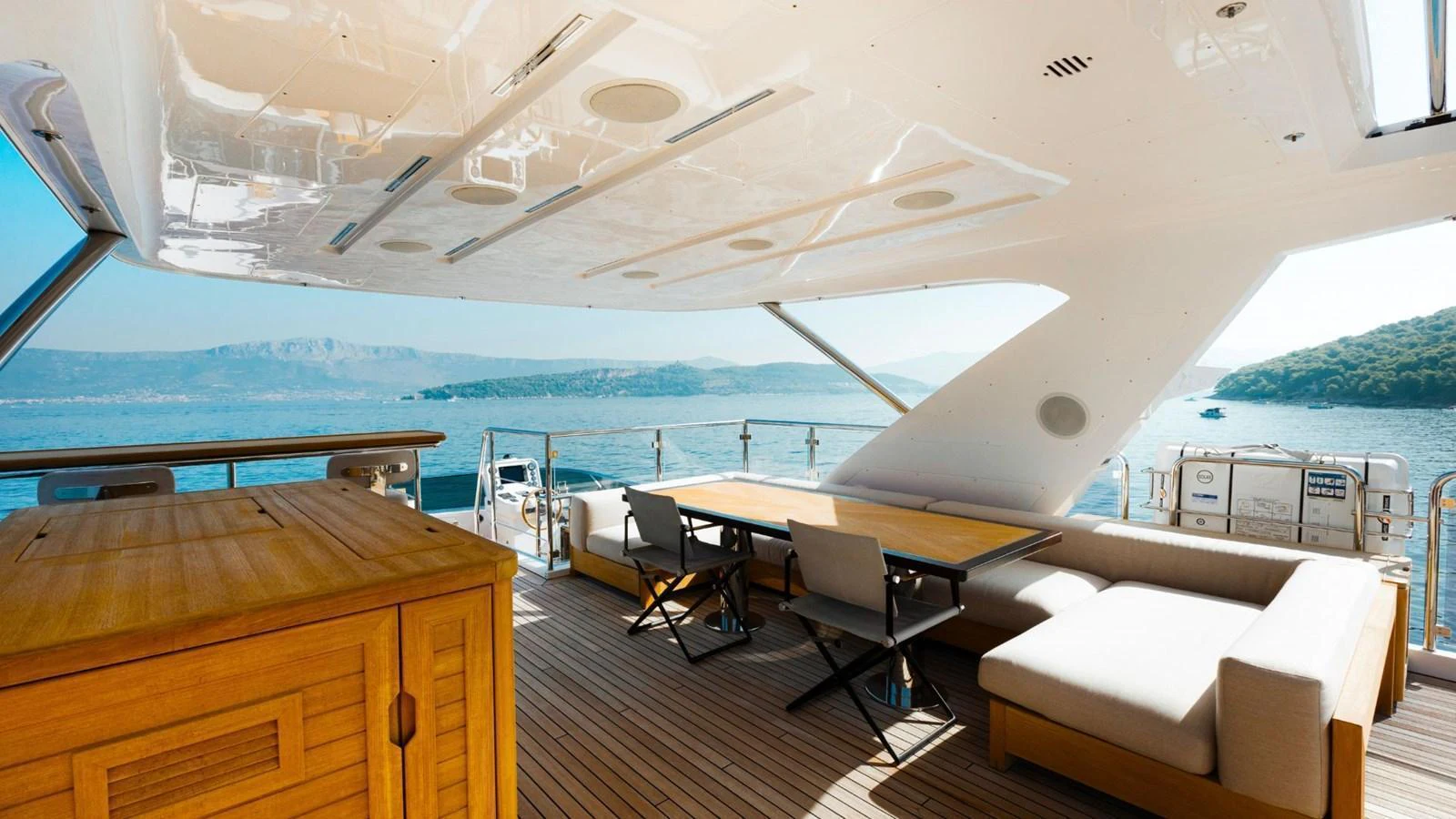 The aft deck offers a spacious and shaded area with comfortable seating and a dining table, perfect for enjoying the scenic views. aboard AFINA Yacht for Sale