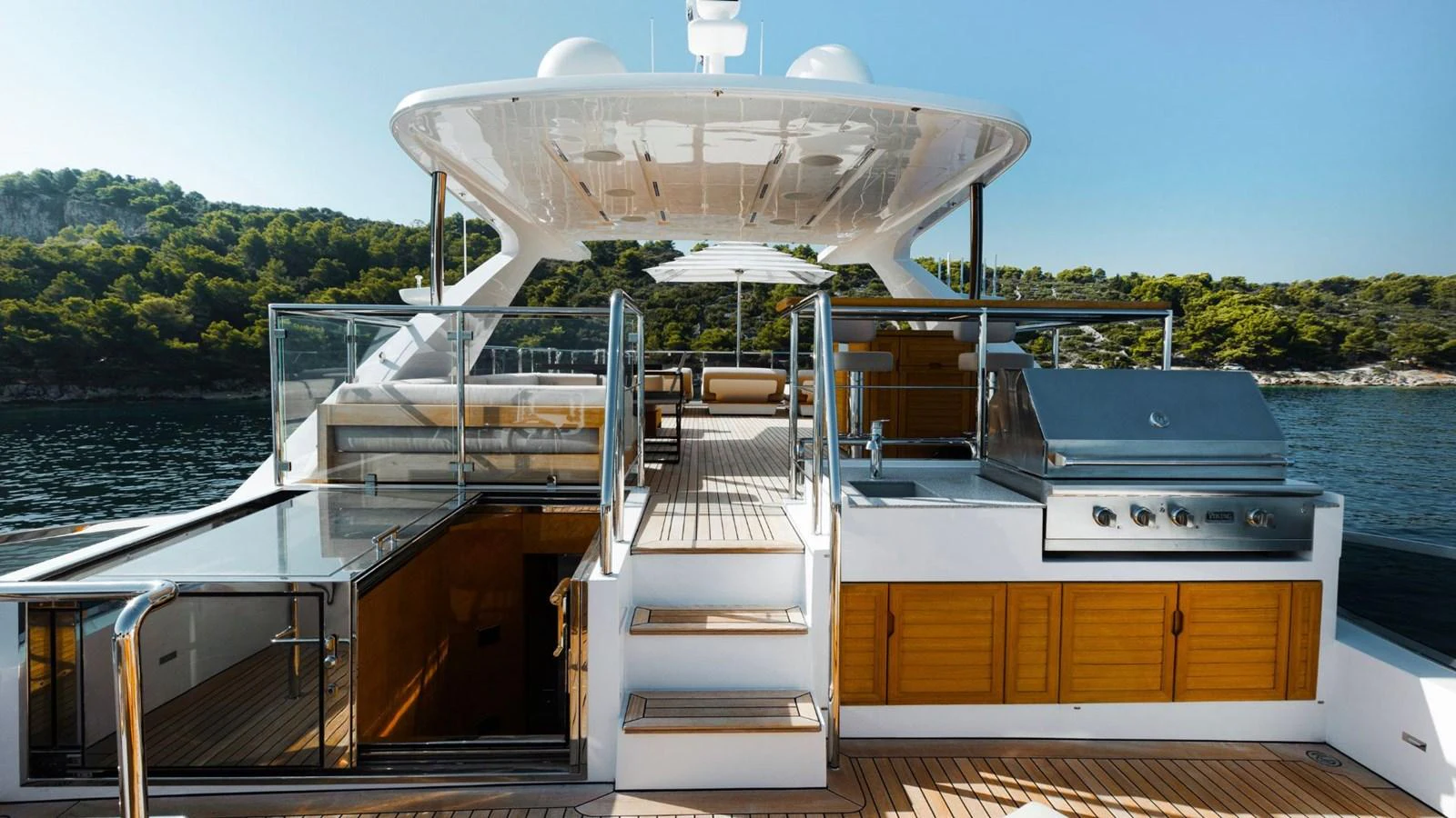 The sundeck features a well-equipped outdoor kitchen and lounging area with beautiful views. aboard AFINA Yacht for Sale