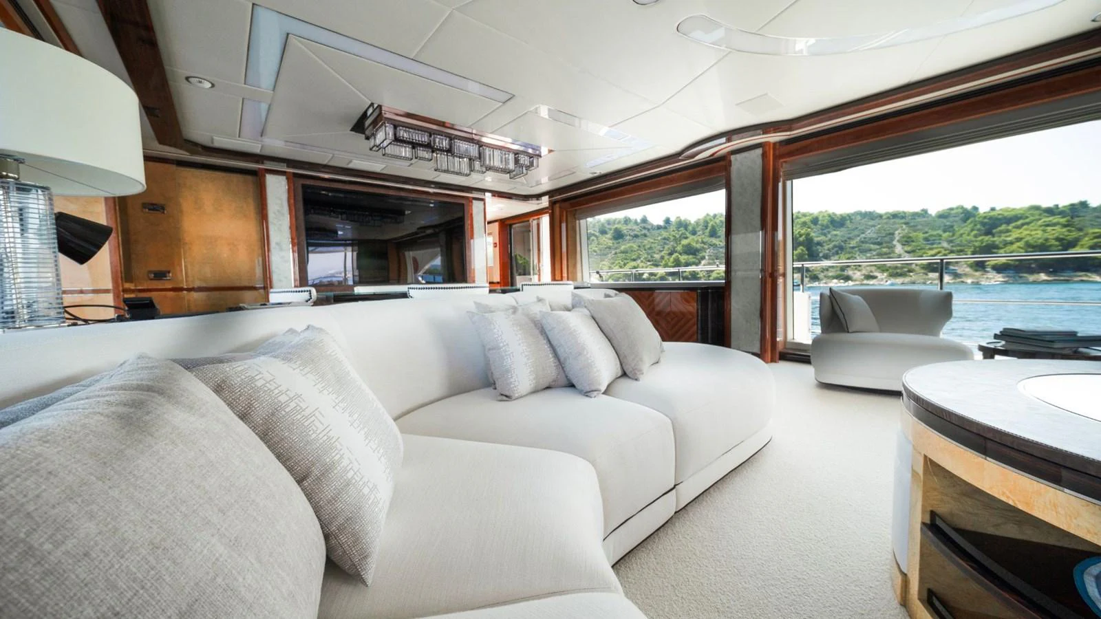 The salon features luxurious seating with expansive windows offering stunning views of the surrounding waters. aboard AFINA Yacht for Sale