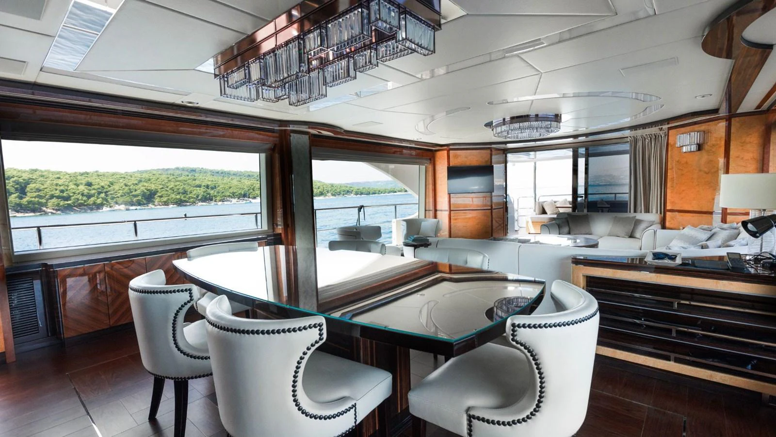 The yacht's salon features luxurious seating and a dining area with panoramic views. aboard AFINA Yacht for Sale