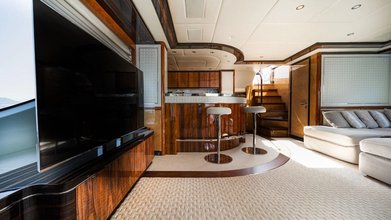 The saloon features a modern entertainment system, comfortable seating, and a stylish bar area. aboard AFINA Yacht for Sale
