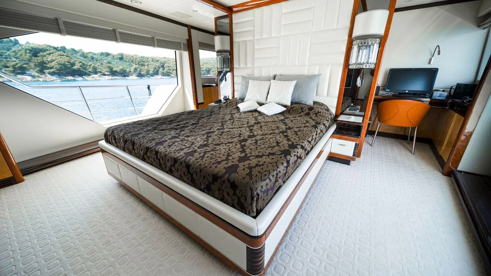 A luxurious stateroom with a large bed and scenic views through the windows. aboard AFINA Yacht for Sale