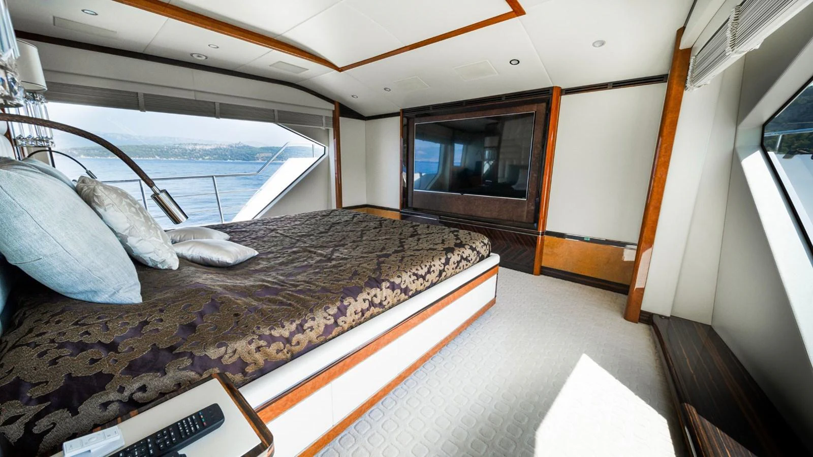 The master stateroom features a luxurious bed with elegant bedding and large windows offering stunning views. aboard AFINA Yacht for Sale