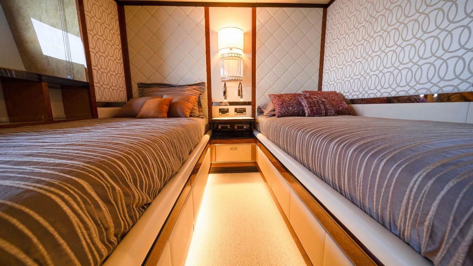 The twin stateroom features two comfortable beds with elegant decor and ambient lighting. aboard AFINA Yacht for Sale