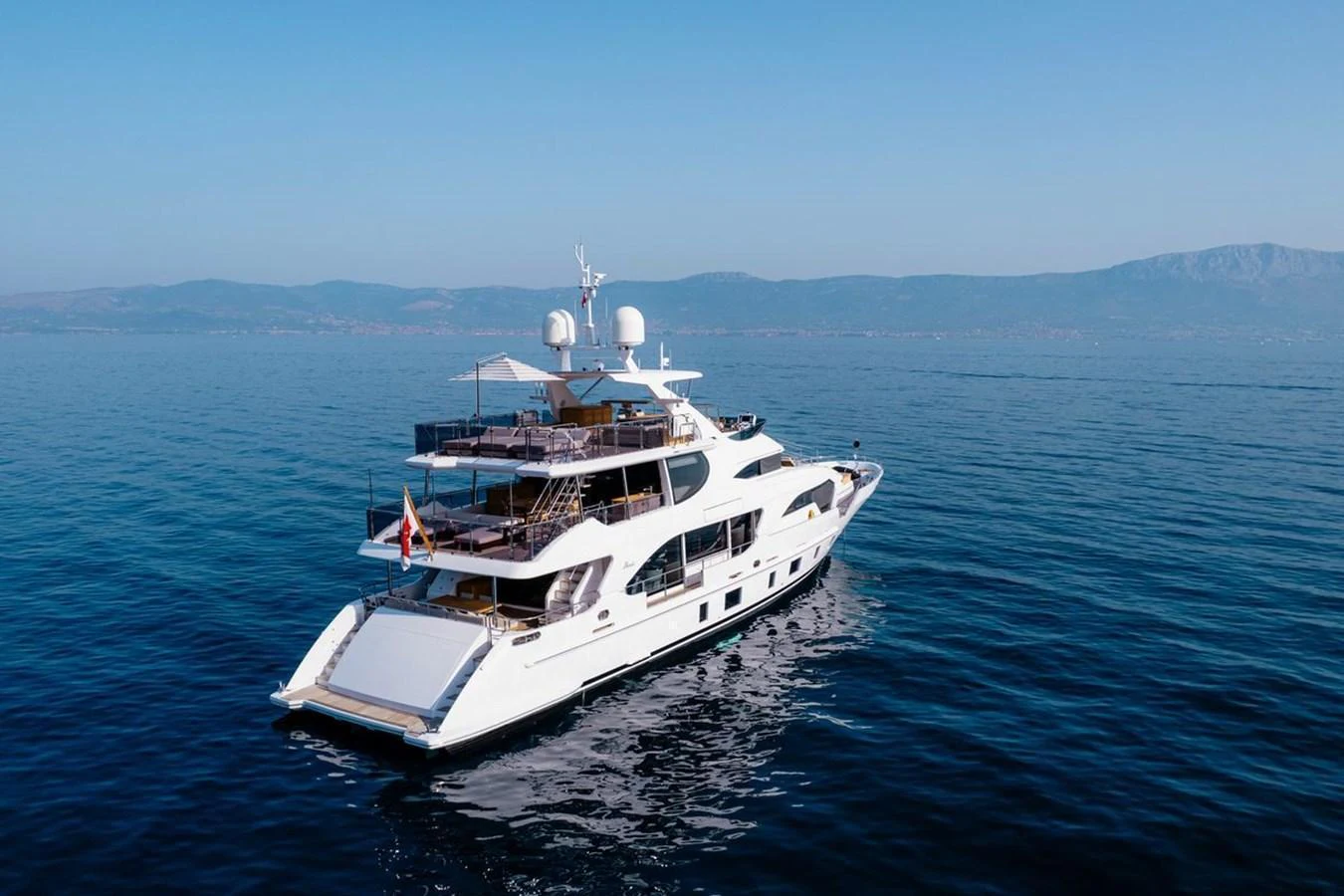 A luxurious yacht cruises gracefully on calm waters with a scenic backdrop. aboard AFINA Yacht for Sale