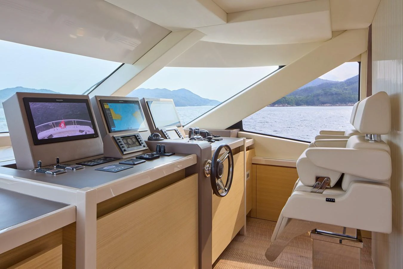 The helm station features modern navigation equipment and comfortable seating with a scenic view. aboard MIRAE Yacht for Sale