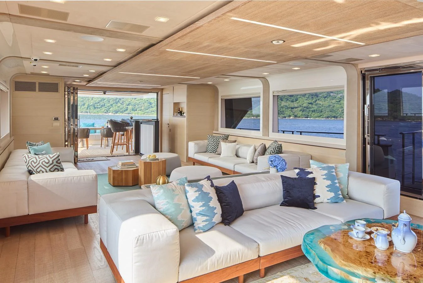The salon features plush seating, a stylish coffee table, and large windows offering stunning ocean views. aboard MIRAE Yacht for Sale