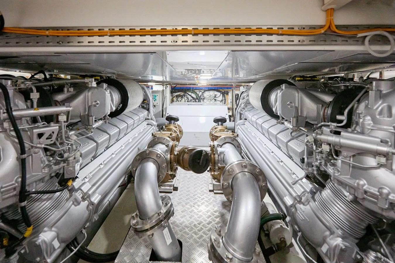 The image showcases the meticulously maintained engine room with powerful engines and polished metal components. aboard MIRAE Yacht for Sale