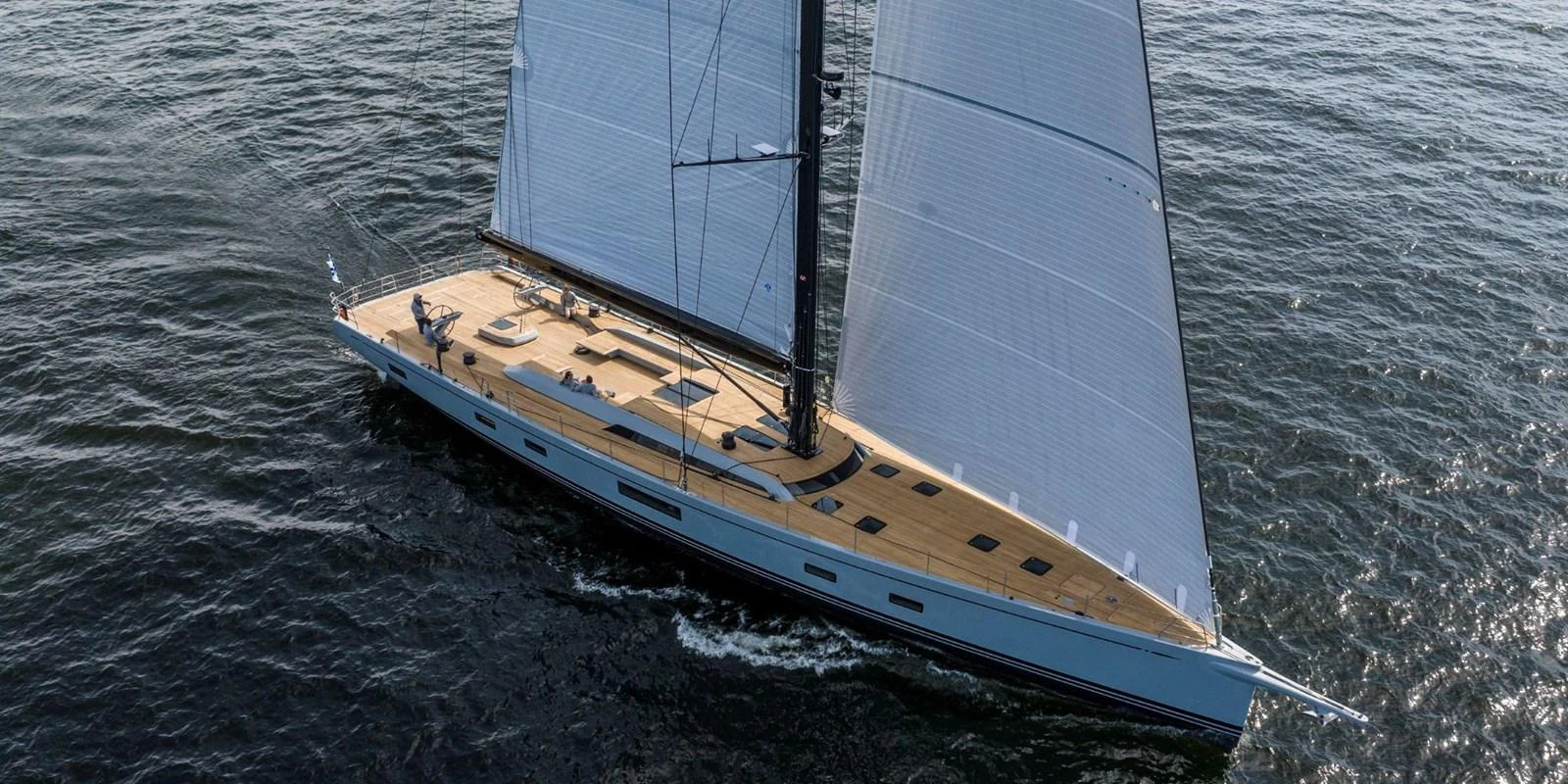 A sleek sailing yacht glides gracefully over the water, showcasing its elegant design and expansive deck. aboard FANCY Yacht for Sale