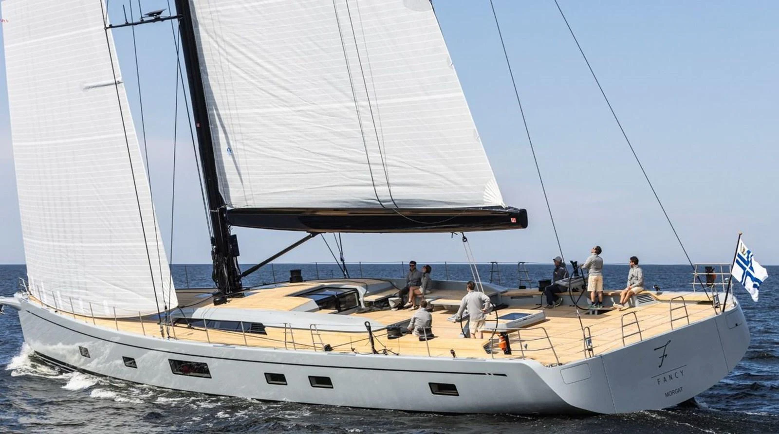 A sleek sailing yacht glides gracefully on the open sea with its sails fully extended. aboard FANCY Yacht for Sale