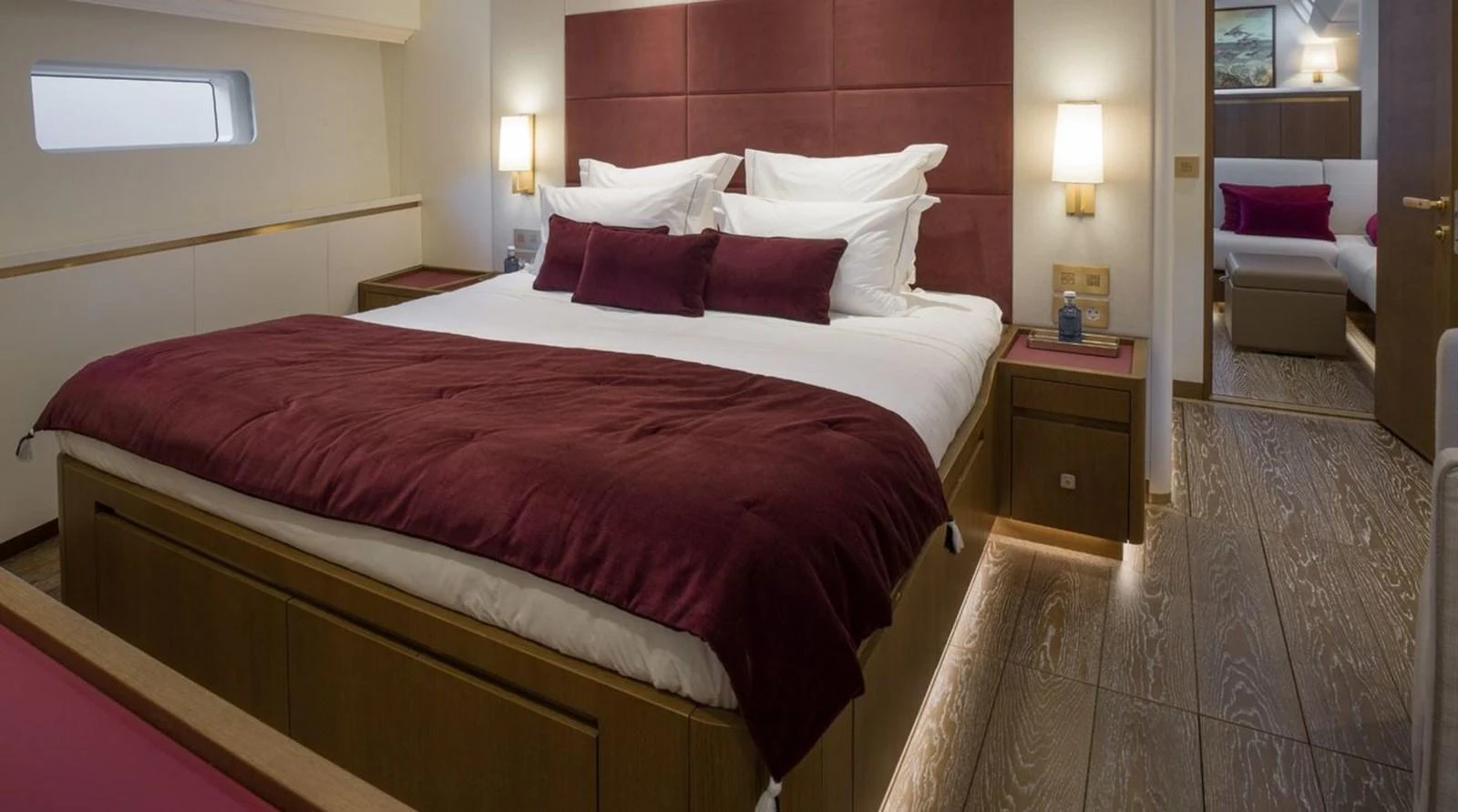 The master stateroom features a luxurious bed with rich burgundy accents and modern lighting. aboard FANCY Yacht for Sale