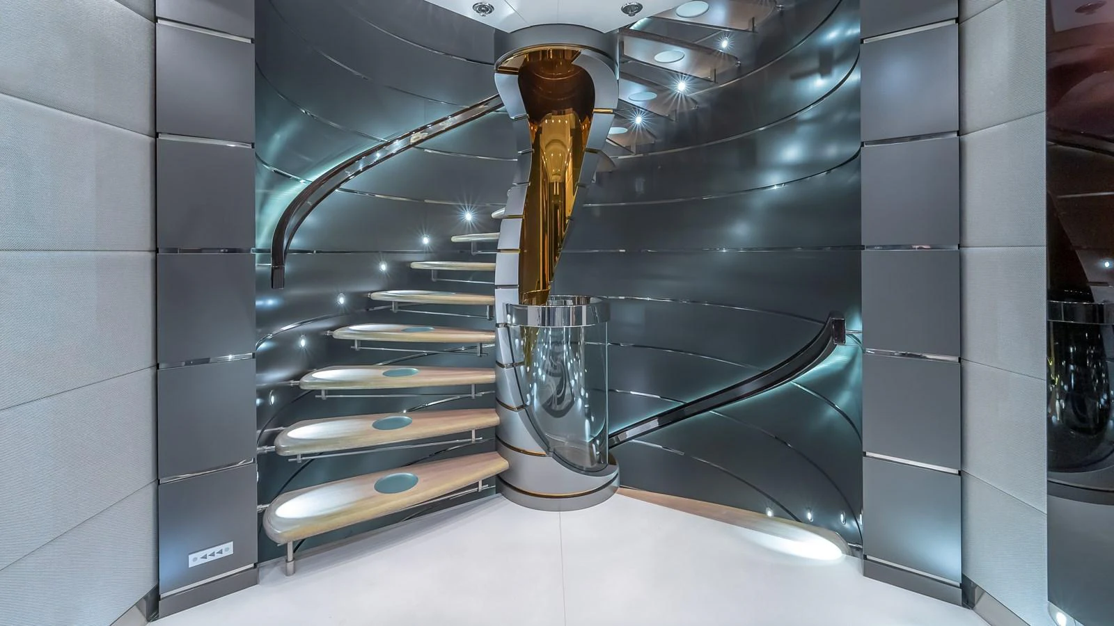 A modern, sleek staircase with metallic finishes and illuminated steps. aboard SCOTT FREE Yacht for Sale