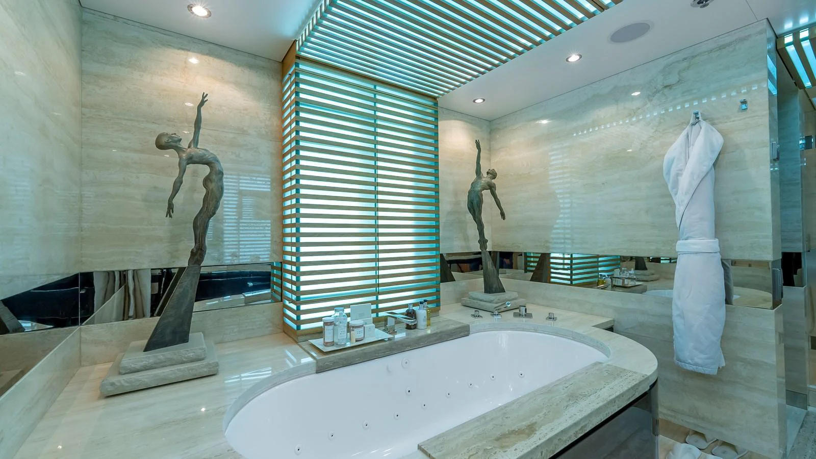 The luxurious bathroom features a modern design with elegant sculptures and ambient lighting. aboard SCOTT FREE Yacht for Sale