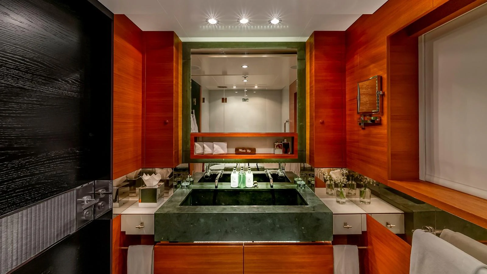 The yacht's bathroom features luxurious wood paneling and a sleek, modern sink area. aboard SCOTT FREE Yacht for Sale