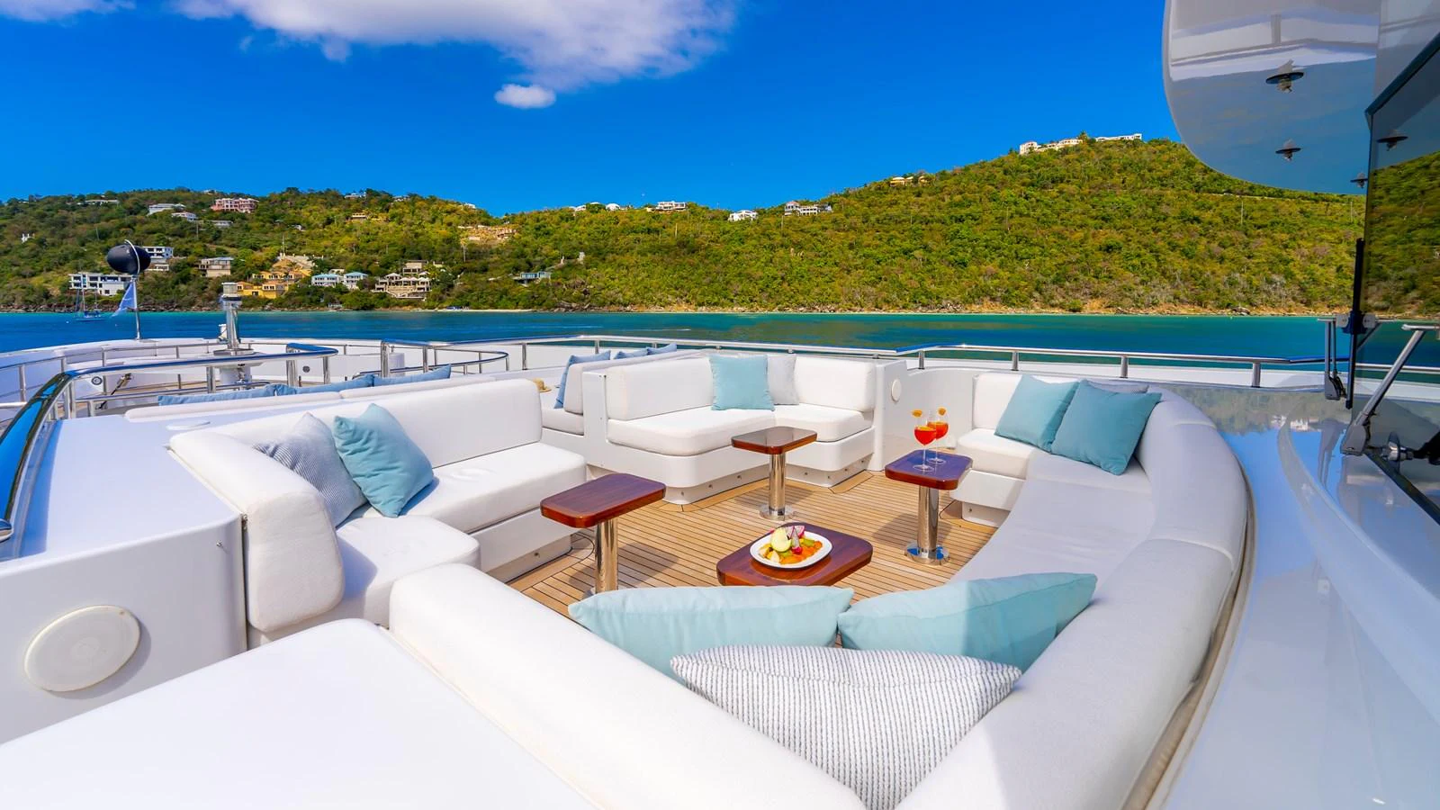The sundeck offers a luxurious seating area with plush white cushions and scenic views. aboard SCOTT FREE Yacht for Sale