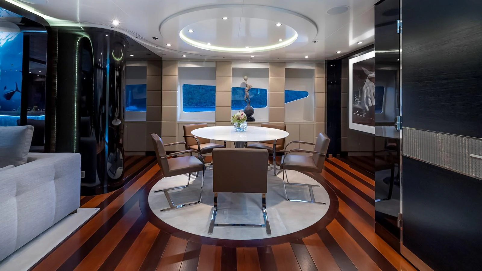 The yacht's dining area features a modern table with stylish chairs, surrounded by elegant decor and ambient lighting. aboard SCOTT FREE Yacht for Sale