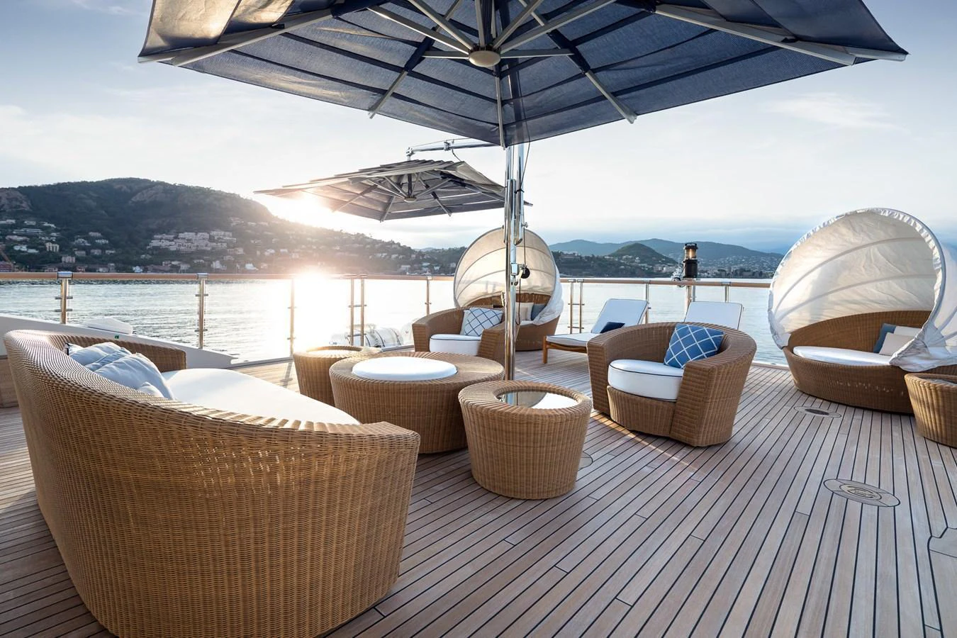 The sundeck offers a luxurious outdoor lounging area with comfortable wicker furniture and large umbrellas, perfect for relaxation and enjoying the view. aboard VISION Yacht for Sale