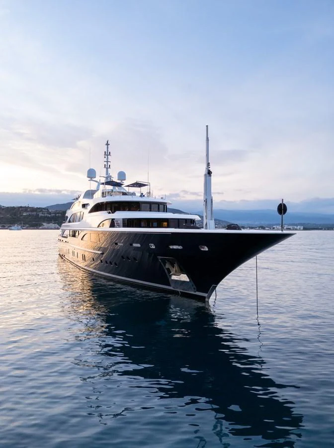 A luxurious yacht is anchored on calm waters during a serene evening. aboard VISION Yacht for Sale