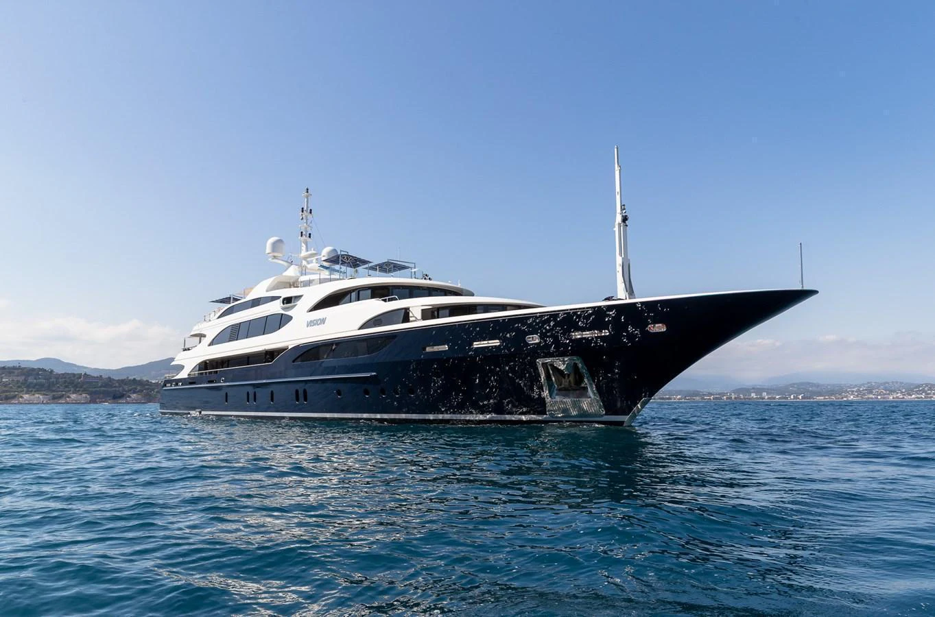 A luxurious yacht glides gracefully on calm waters under a clear blue sky. aboard VISION Yacht for Sale
