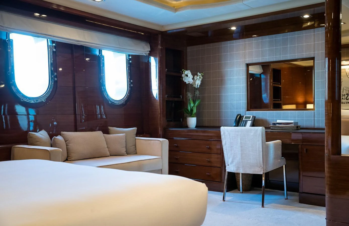 The stateroom features elegant wood paneling, a comfortable seating area, and a well-appointed desk. aboard VISION Yacht for Sale