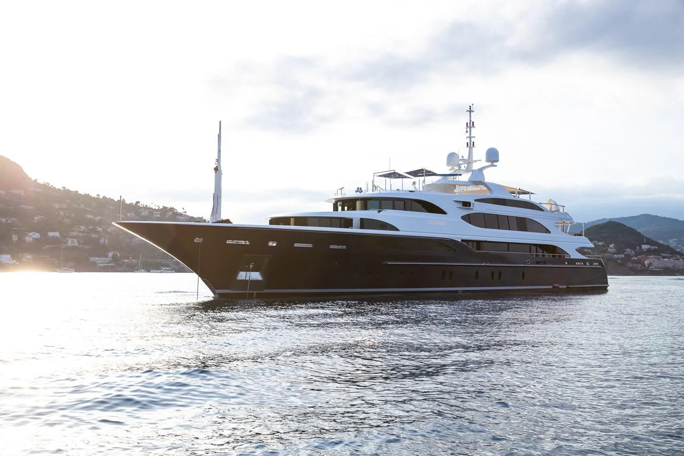A luxurious yacht glides gracefully on calm waters against a scenic backdrop. aboard VISION Yacht for Sale