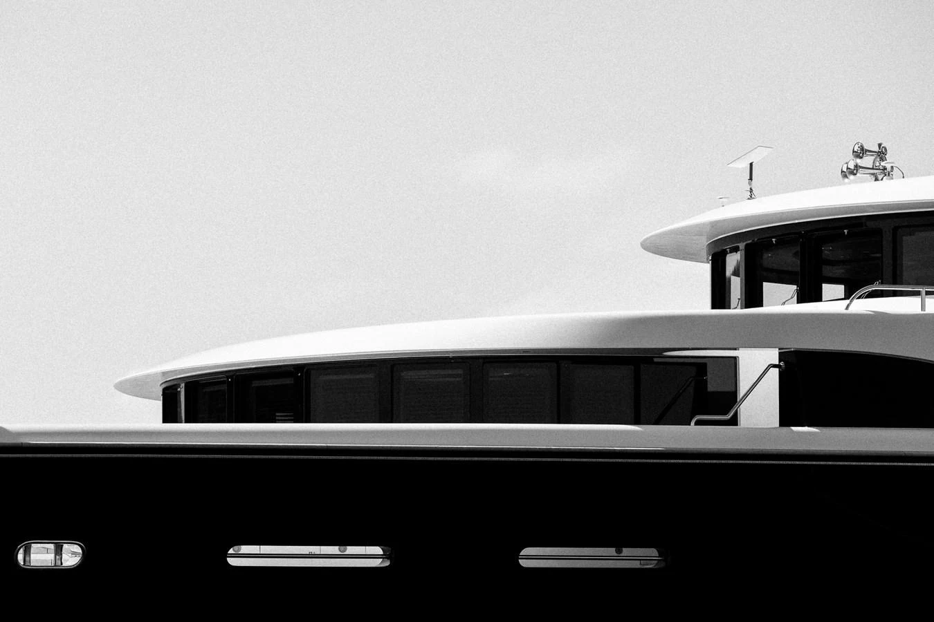 A close-up black and white image showcasing the sleek lines and modern design of a yacht's superstructure. aboard VISION Yacht for Sale