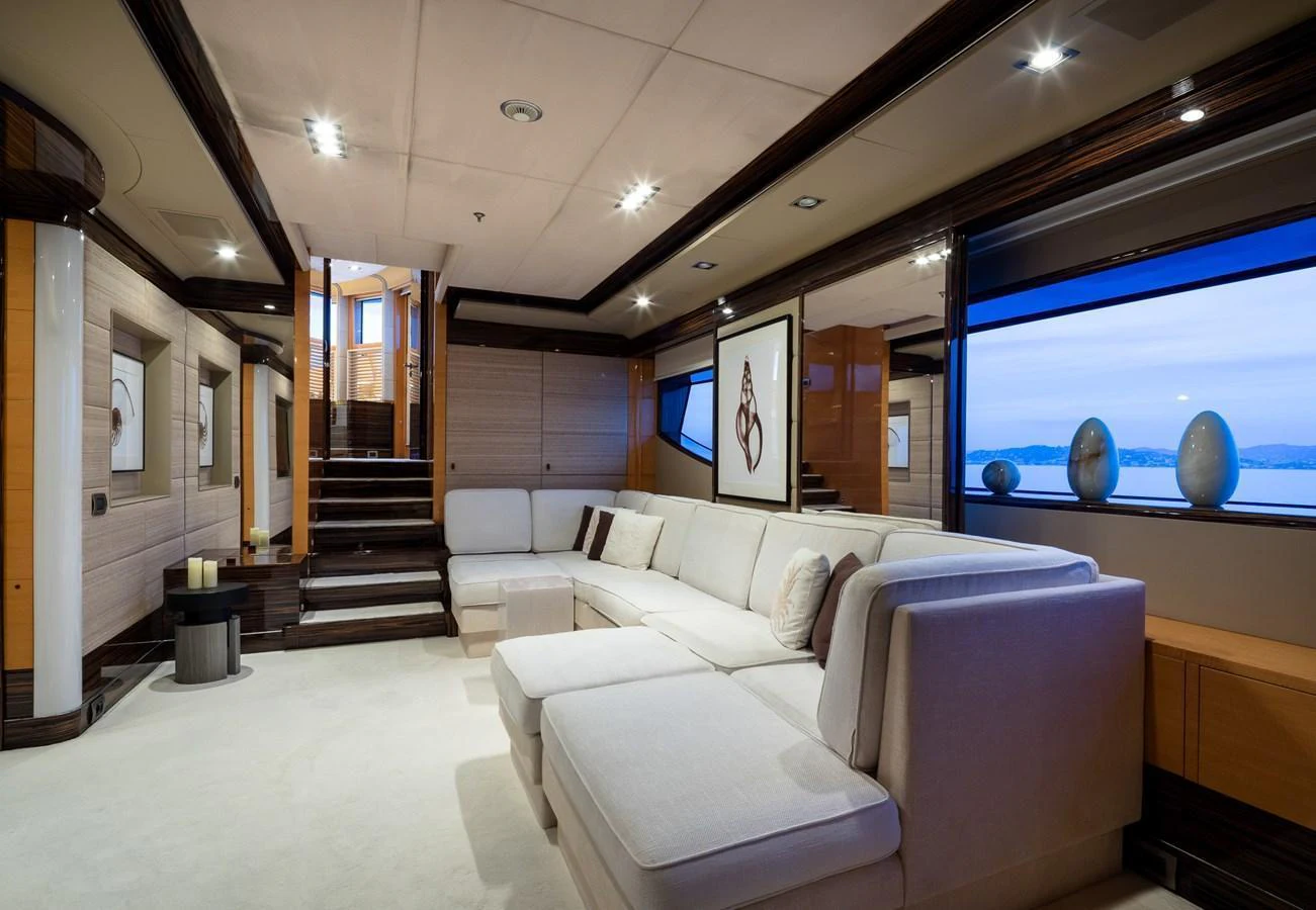 The salon offers a spacious and luxurious seating area with elegant decor and large windows providing scenic views. aboard VISION Yacht for Sale