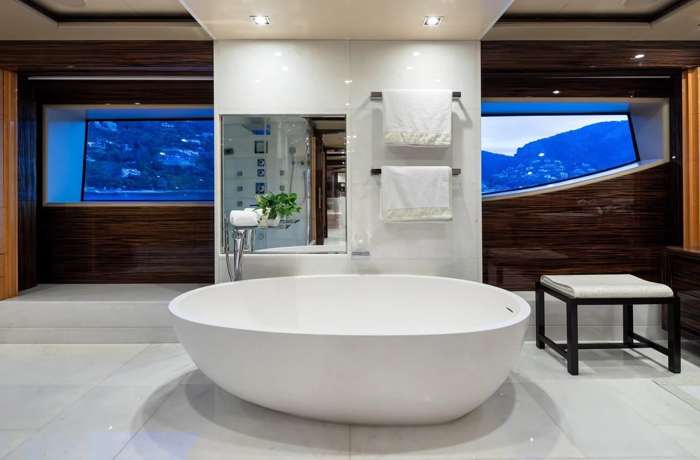 The yacht's bathroom features a luxurious freestanding bathtub with scenic views through large windows. aboard VISION Yacht for Sale