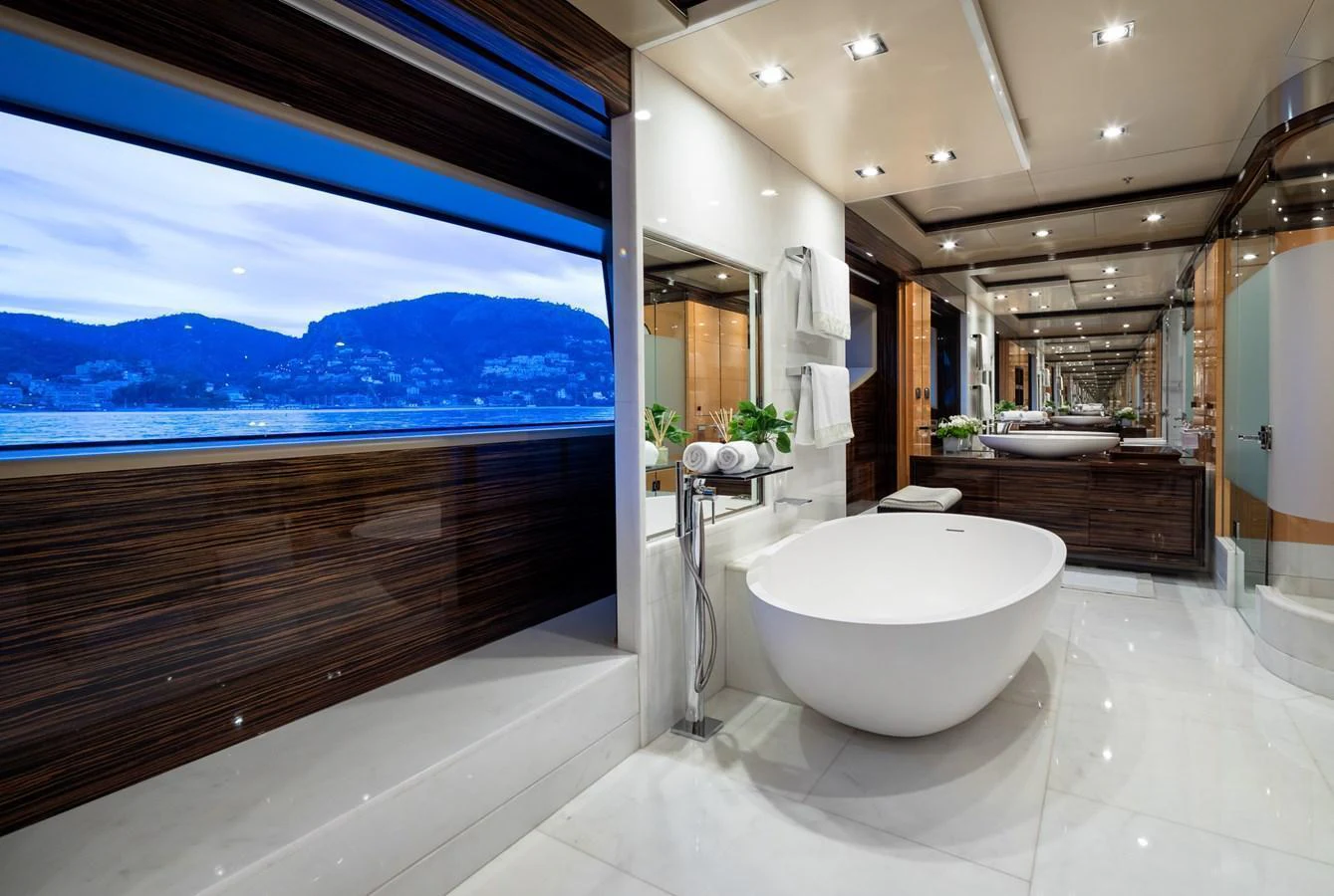 The luxurious bathroom features a freestanding tub with a stunning view of the sea through large windows. aboard VISION Yacht for Sale