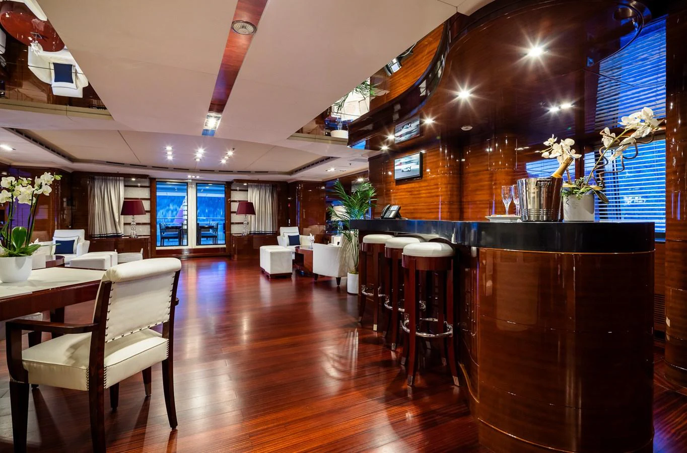 The yacht's salon features elegant wood finishes, plush seating, and a sophisticated bar area. aboard VISION Yacht for Sale
