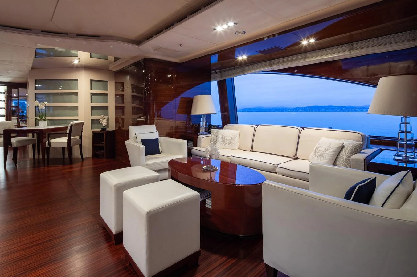 The salon features elegant furnishings with a stunning view of the sea through large windows. aboard VISION Yacht for Sale